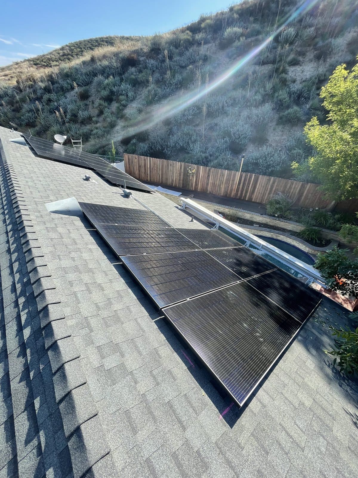 Two solar panel arrays on a composition shingle roof of a hillside home in Santa Clarita, CA